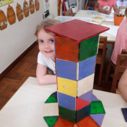 Sophie builds a tower out of magnetics.