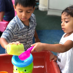 Avraan and Mira having fun at the water table.