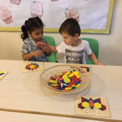 Avyanna and Thomas working together to solve shape puzzles.