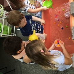 Katie, Enzo, August and Matilda enjoy scooping and pouring at the water table.
