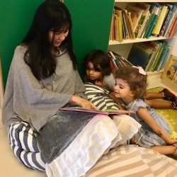 Ravi and Florence enjoyed hearing Ms. Angie read a story.