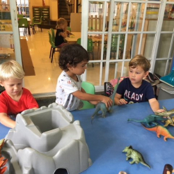 Eddie, Ravi, and Max had fun playing together with the dinosaurs.