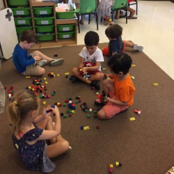 Fun building with linking cubes on the carpet.