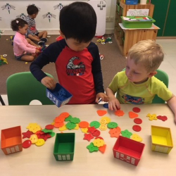 Samuel and James check out a button sorting activity.