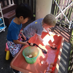 Samuel and James had fun scooping eggs in the water table.