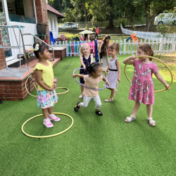 Girls having fun with the hula hoops and their pretend game.