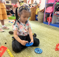 Lucy exercising her fine motor skills by screwing and unscrewing.