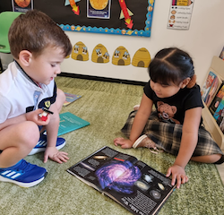 Oscar and Kassie learning about the galaxy .