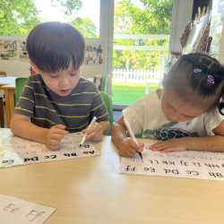 Trevor and Lucy doing a great job practicing their letter formation.