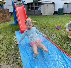 Action shot of Izzy sliding down the slide!
