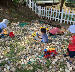 Charlie, Hugo ,Romy and Rowan enjoying using the diggers to pick up the stones!