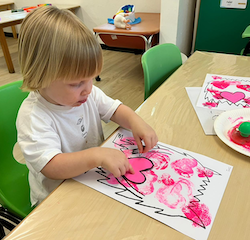 Izzy making her love monster using heart stamps!