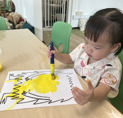 Maya painting her yellow colour monster