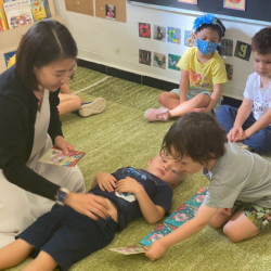 Benji measuring Charlie’s body length using red envelopes