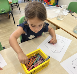 Mia colouring her kite with her favourite pink!