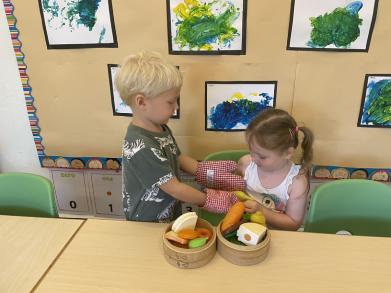 Charlie is serving Lily some food.