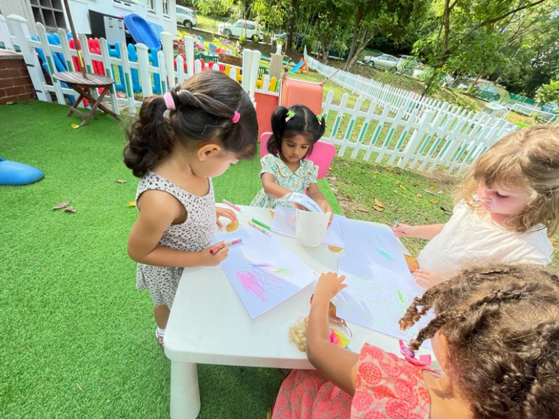 Clemmie, Lydia, Kaavya and Alara engaged in outdoor art and doing leaf rubbings.