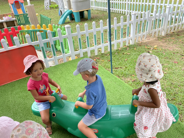 Henry, Kaavya and Lydia playing on the seesaw together.