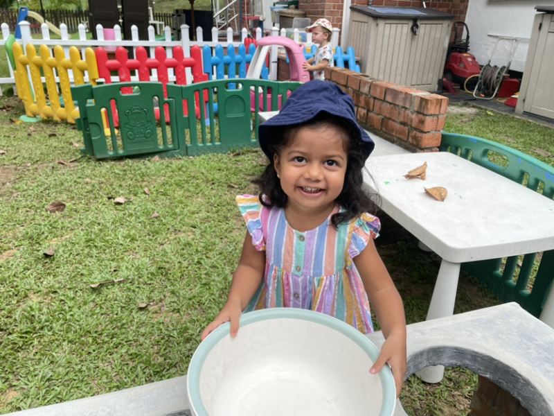 Savhara playing in the outside kitchen.