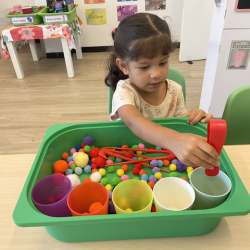 Alara practising her fine motor skills and colour sorting.