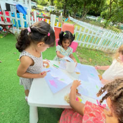 Clemmie, Lydia, Kaavya and Alara engaged in outdoor art and doing leaf rubbings.