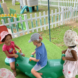 Henry, Kaavya and Lydia playing on the seesaw together.