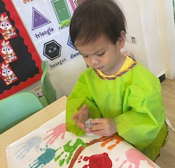 Avery adding his handprint to the Fireflies friendship tree.
