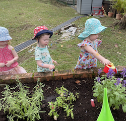George, Isla and Isabelle watering the garden patch.
