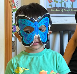 Kathavya trying on a butterfly mask during Mandarin class.