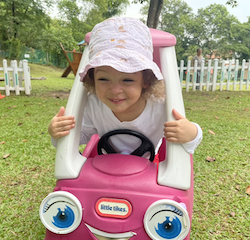 Norielle is going for a ride in the pink car.