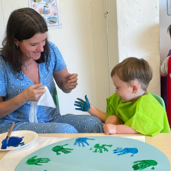 Skyler adding his handprint to our Earth day collaborative art.