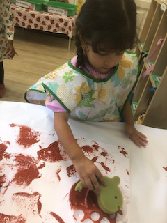 Alara helps to paint mud paint for our book week board.