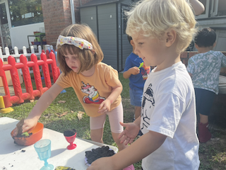 Clemmie and Rowan preparing mud pie during mud kitchen time!