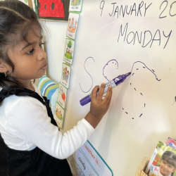 Kaavya practising writing letter “S” on the white board!