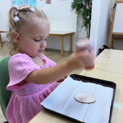 Ella sprinkling glitter onto her Easter egg