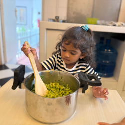 Sara helping to toss the pasta and mixing until nicely coated!
