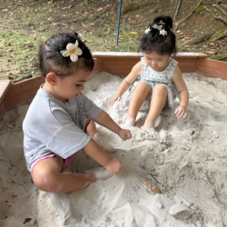Skyla and Ellie having fun covering their feet in sand!