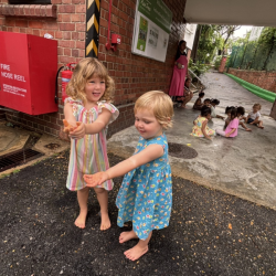 Immy and Ollie giggling as they catch raindrops – who needs sunshine when you’ve got puddles and pals?