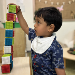 Carefully stacking stick blocks to build the tallest tower—will it topple or stand tall?