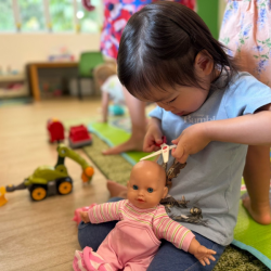 Constance giving her baby doll a hair cut *snip snip*