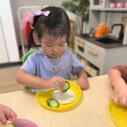 Constance made a tasty snack for morning tea—corn thins topped with cream cheese and cucumber slices! 🥒🧀😋