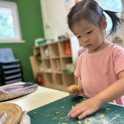 Constance tore dried petals by hand, pressing them into her clay piece