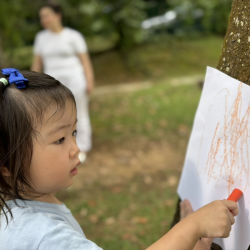 Exploring textures with tree bark rubbings—what patterns can she find?