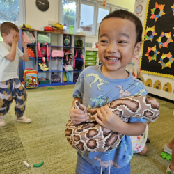 Ei pretending to be trapped around our friendly soft toy snake