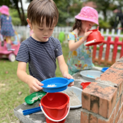 Trevor having a great time at mud kitchen.