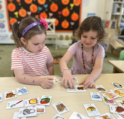 Vivi and Paige working together on their rhyming words puzzle.