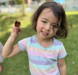Myla excitedly showing her heart shape leaf that she found in the garden.