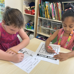 Paige and Reina practicing reading and writing.