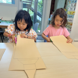 Toria and Myla focusing on their cutting skills.