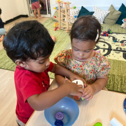 Aarav & Alba working together to put the coins in the pot!